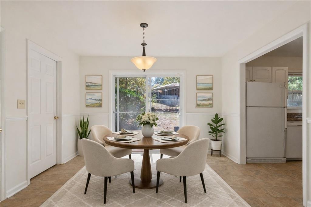 4433 Locksley Road Tucker, GA 30084 - Photo 7 of 33 a dining room with furniture a chandelier and wooden floor