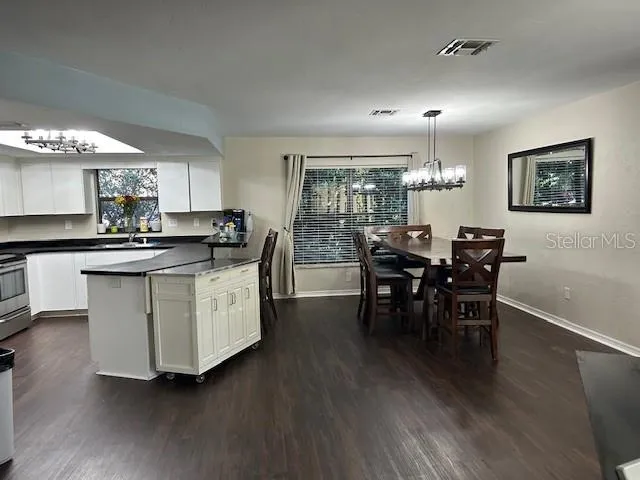 a kitchen with stainless steel appliances granite countertop wooden floors and table