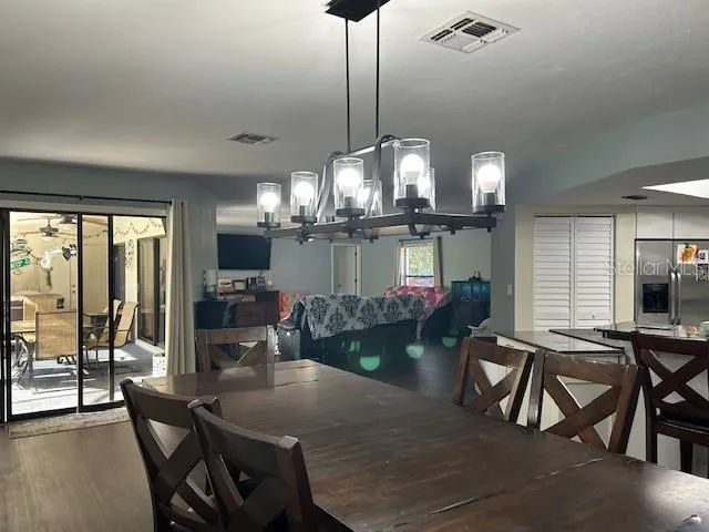 a view of a dining room with furniture and chandelier