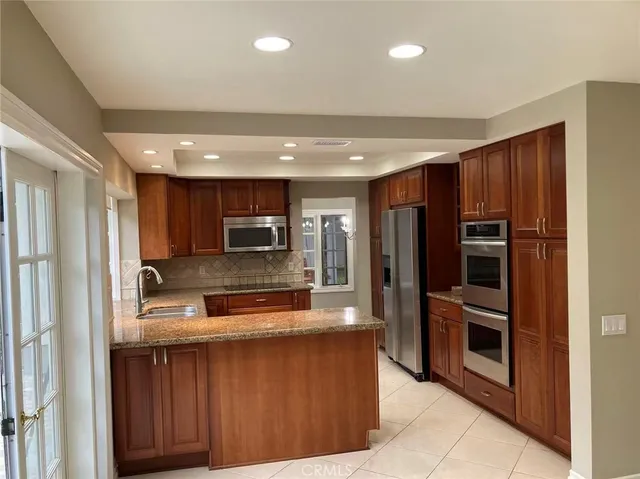 a kitchen with stainless steel appliances granite countertop a refrigerator and a sink