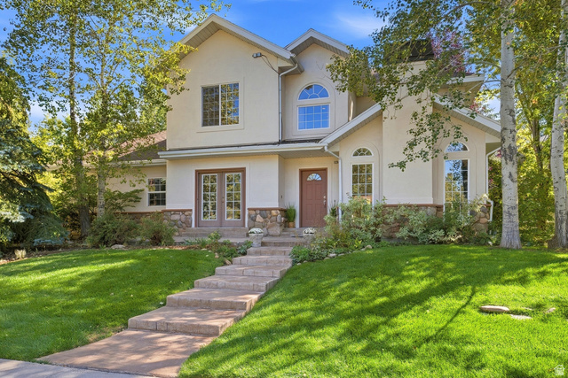 1462 Rio Grande Road Park City, UT 84098 - Photo 1 of 30 Stucco exterior with stone accents, arched windows, transom windows, double French doors, and mature trees