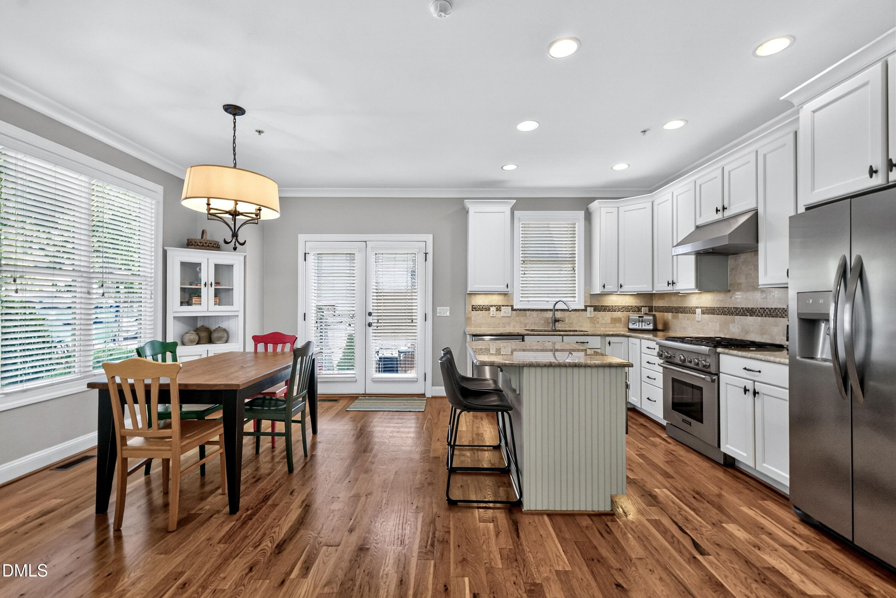 2745 Oberlin Road, Unit 103 Raleigh, NC 27608 - Photo 5 of 23 a kitchen with stainless steel appliances granite countertop a kitchen island hardwood floor sink stove dining table and chairs