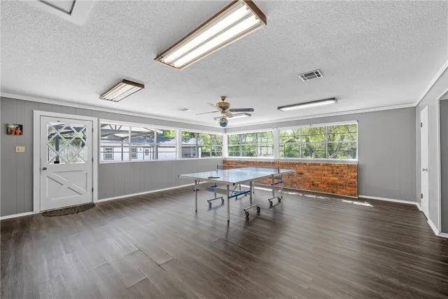 a room with wooden floor and pool table