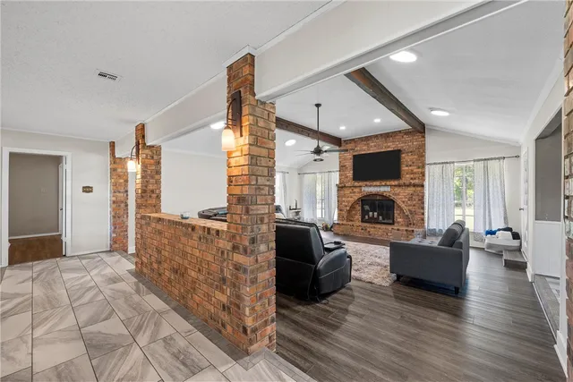 a living room with furniture a fireplace and a flat screen tv