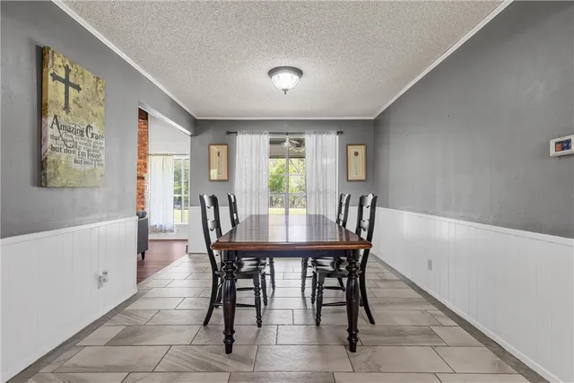 a kitchen with stainless steel appliances granite countertop a table chairs sink refrigerator and microwave