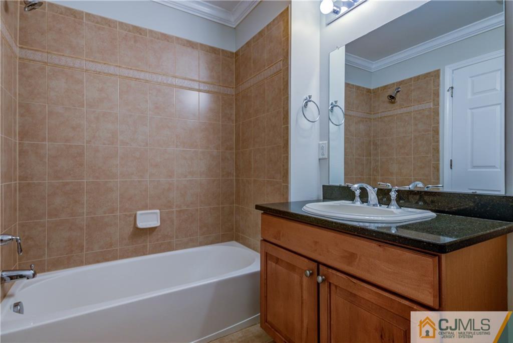 358 Rector Street, Unit 607 Perth Amboy, NJ 08861 - Photo 14 of 25 a bathroom with a granite countertop sink a mirror a bathtub and shower