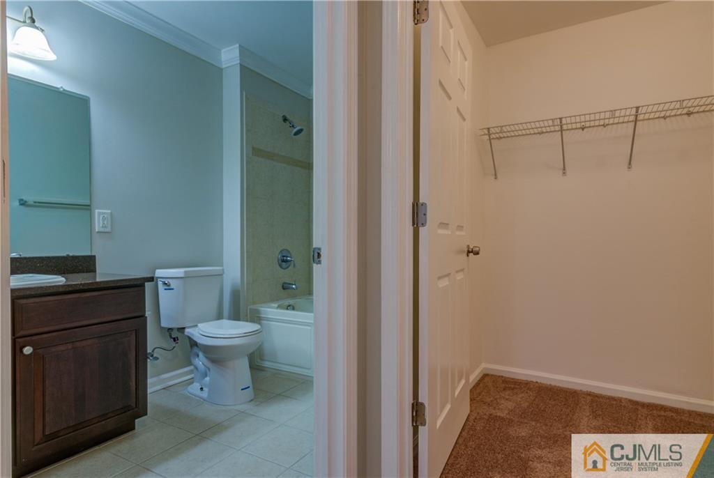 358 Rector Street, Unit 607 Perth Amboy, NJ 08861 - Photo 22 of 25 a bathroom with a granite countertop toilet and a sink