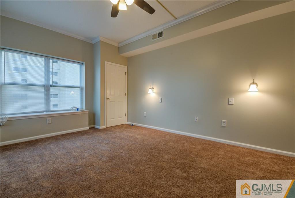 358 Rector Street, Unit 607 Perth Amboy, NJ 08861 - Photo 23 of 25 en empty room with windows and ceiling fan