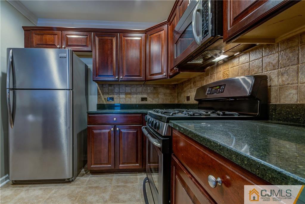 358 Rector Street, Unit 607 Perth Amboy, NJ 08861 - Photo 9 of 25 a kitchen with a refrigerator and a sink