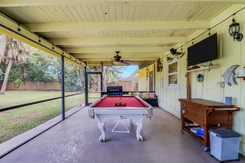 a view of a patio with couches table and chairs under an umbrella