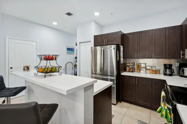 a kitchen with stainless steel appliances a refrigerator sink and wooden cabinets