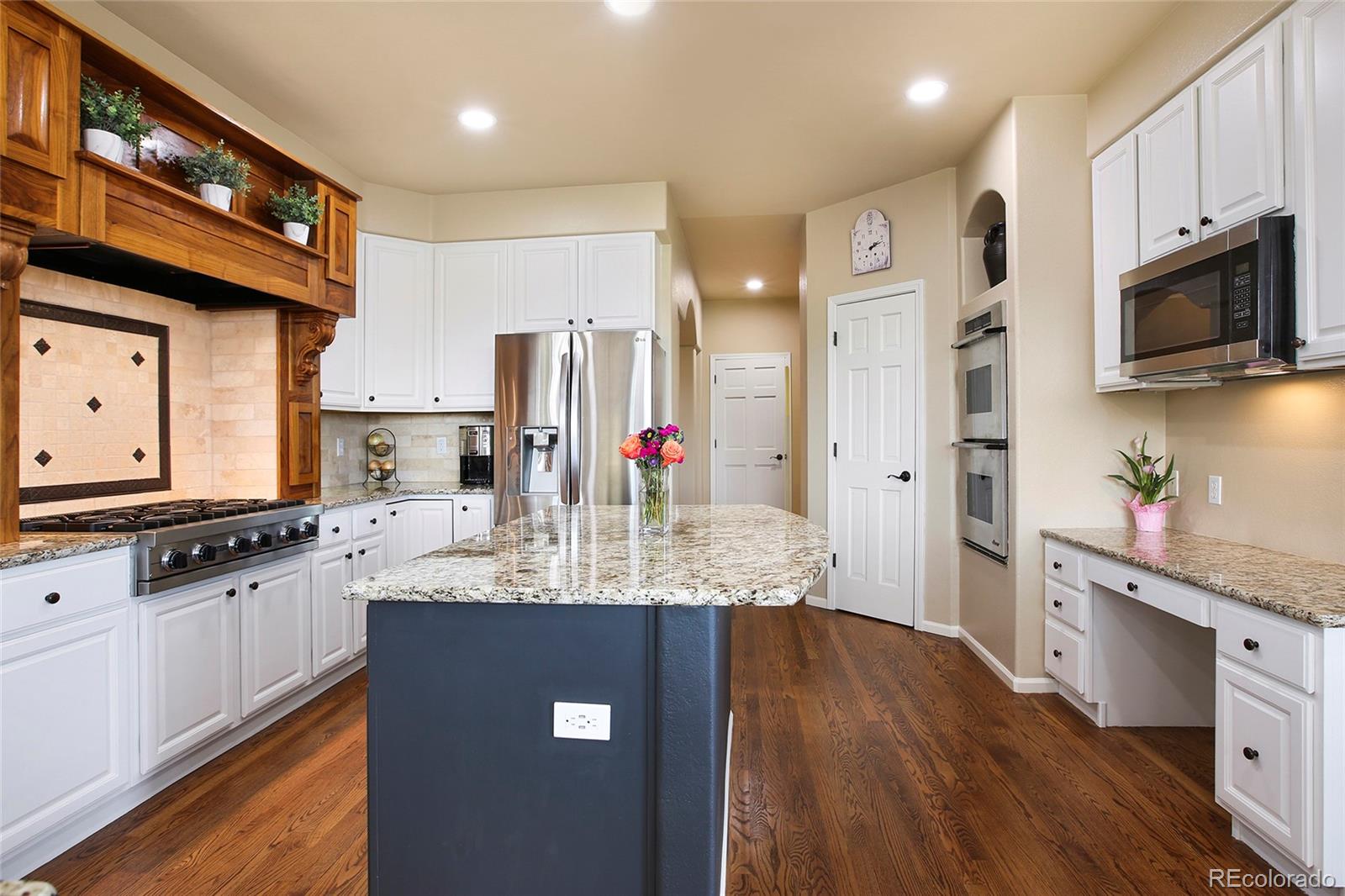 7768 Edgewater Court Lone Tree, CO 80124 - Photo 11 of 39 a kitchen with stainless steel appliances granite countertop a sink stove and refrigerator