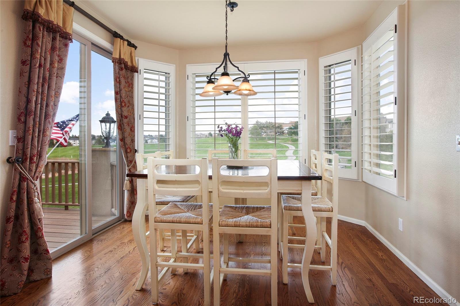 7768 Edgewater Court Lone Tree, CO 80124 - Photo 12 of 39 a view of a dining room with furniture large windows and wooden floor