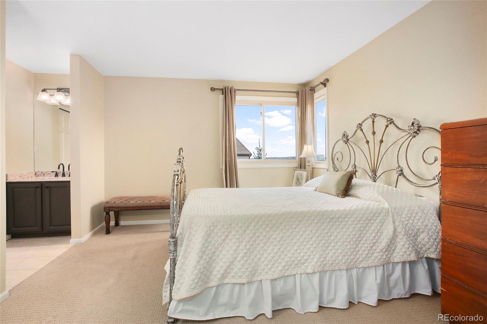 7768 Edgewater Court Lone Tree, CO 80124 - Photo 21 of 39 a bedroom with a bed and a chair