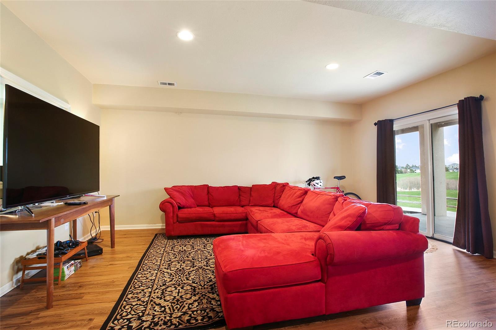 7768 Edgewater Court Lone Tree, CO 80124 - Photo 28 of 39 a living room with furniture and a flat screen tv