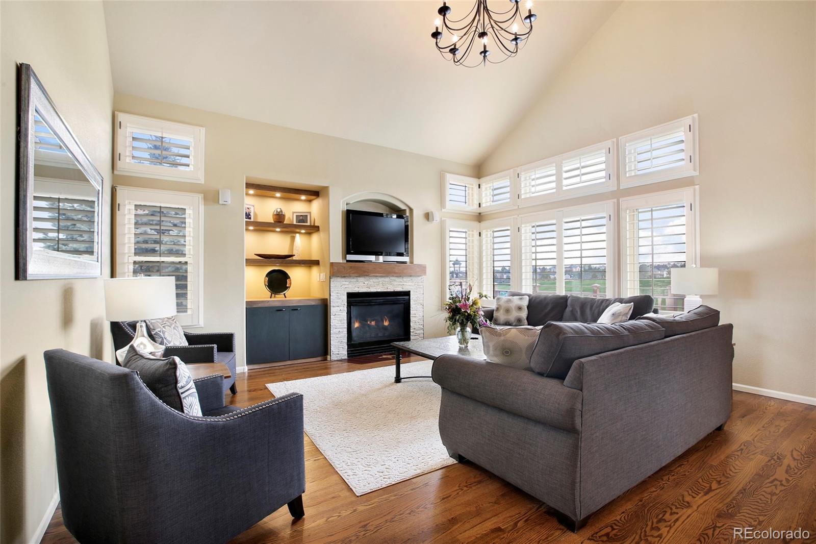 7768 Edgewater Court Lone Tree, CO 80124 - Photo 8 of 39 a living room with furniture a large window and a fireplace