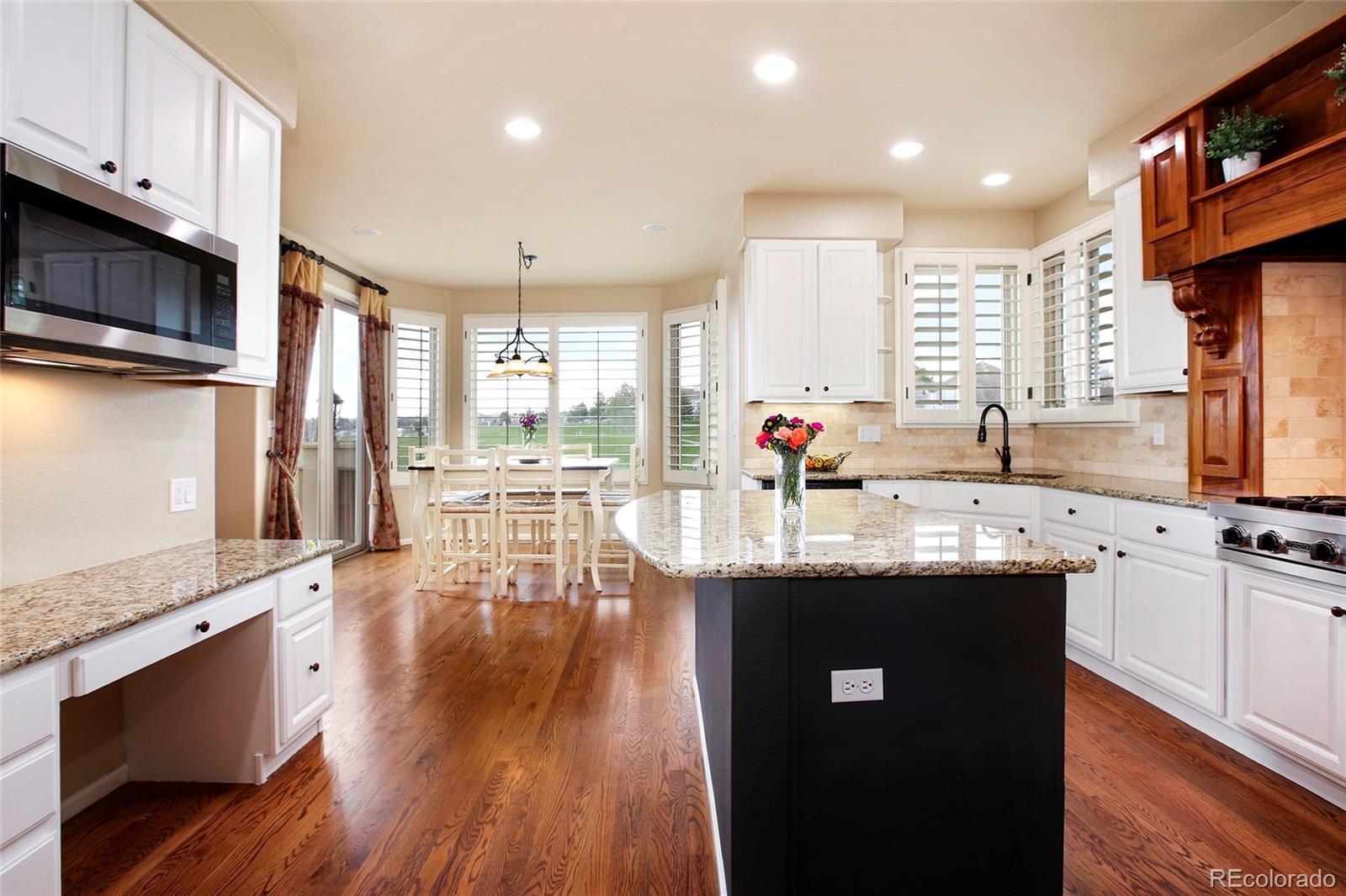 7768 Edgewater Court Lone Tree, CO 80124 - Photo 10 of 39 a kitchen with stainless steel appliances granite countertop a sink a stove and a wooden floors