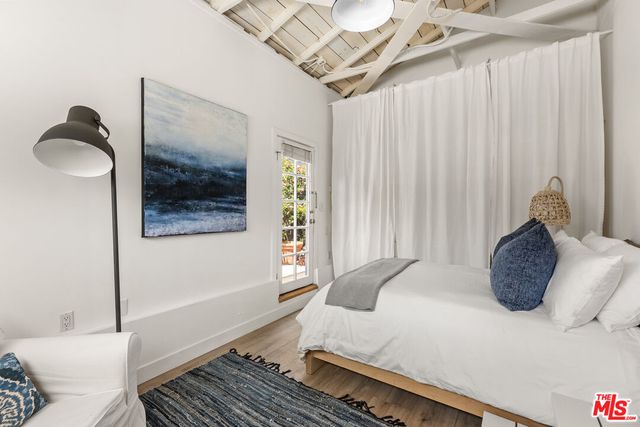 a bedroom with bed and wooden floor