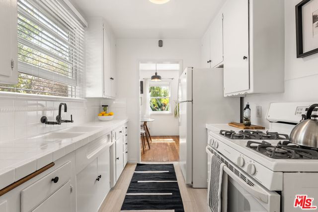 a kitchen with a sink stove and cabinets