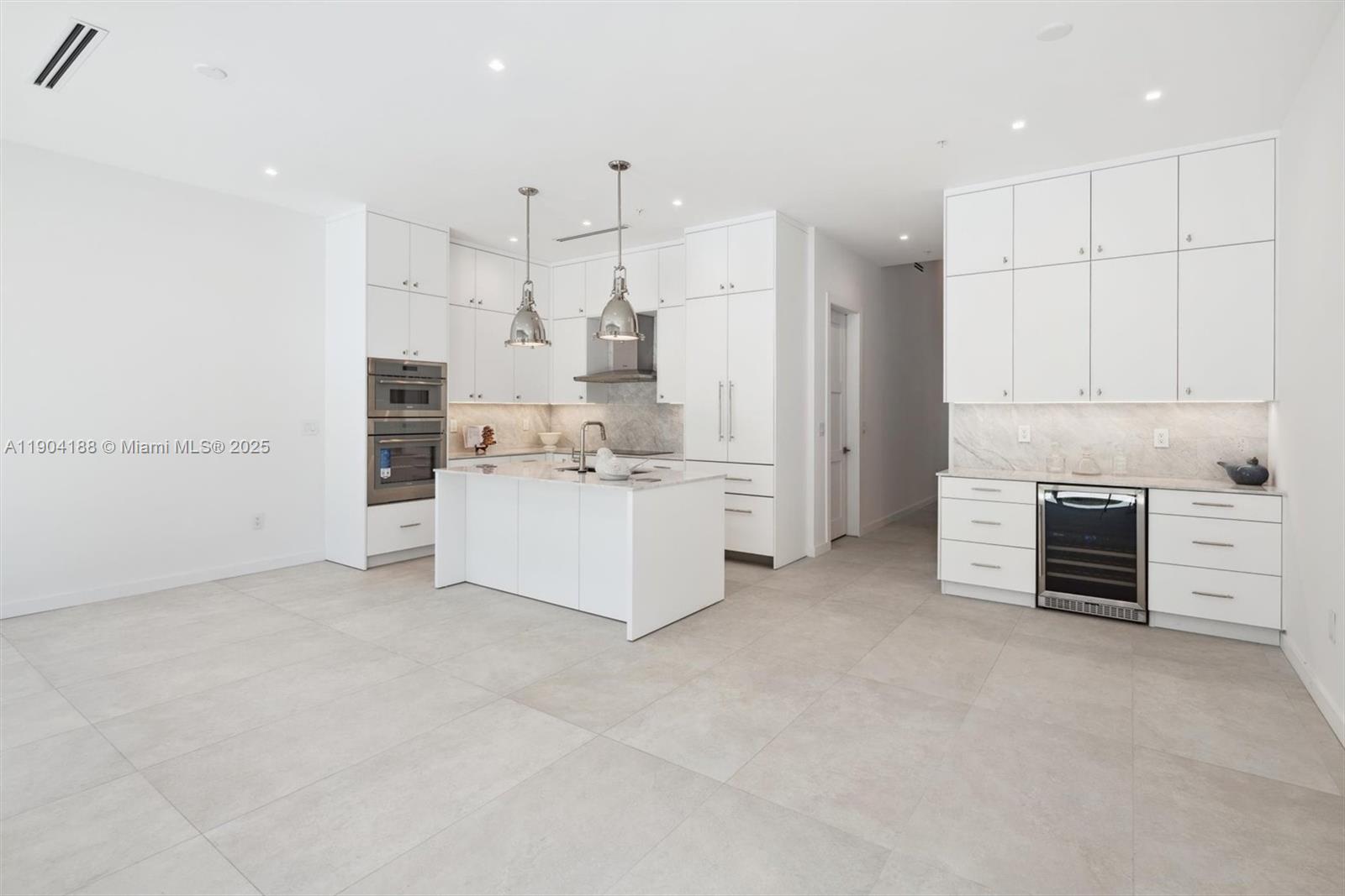 554 North Riverside Drive, Unit B Pompano Beach, FL 33062 - Photo 10 of 48 a kitchen with stainless steel appliances kitchen island granite countertop a stove and a refrigerator