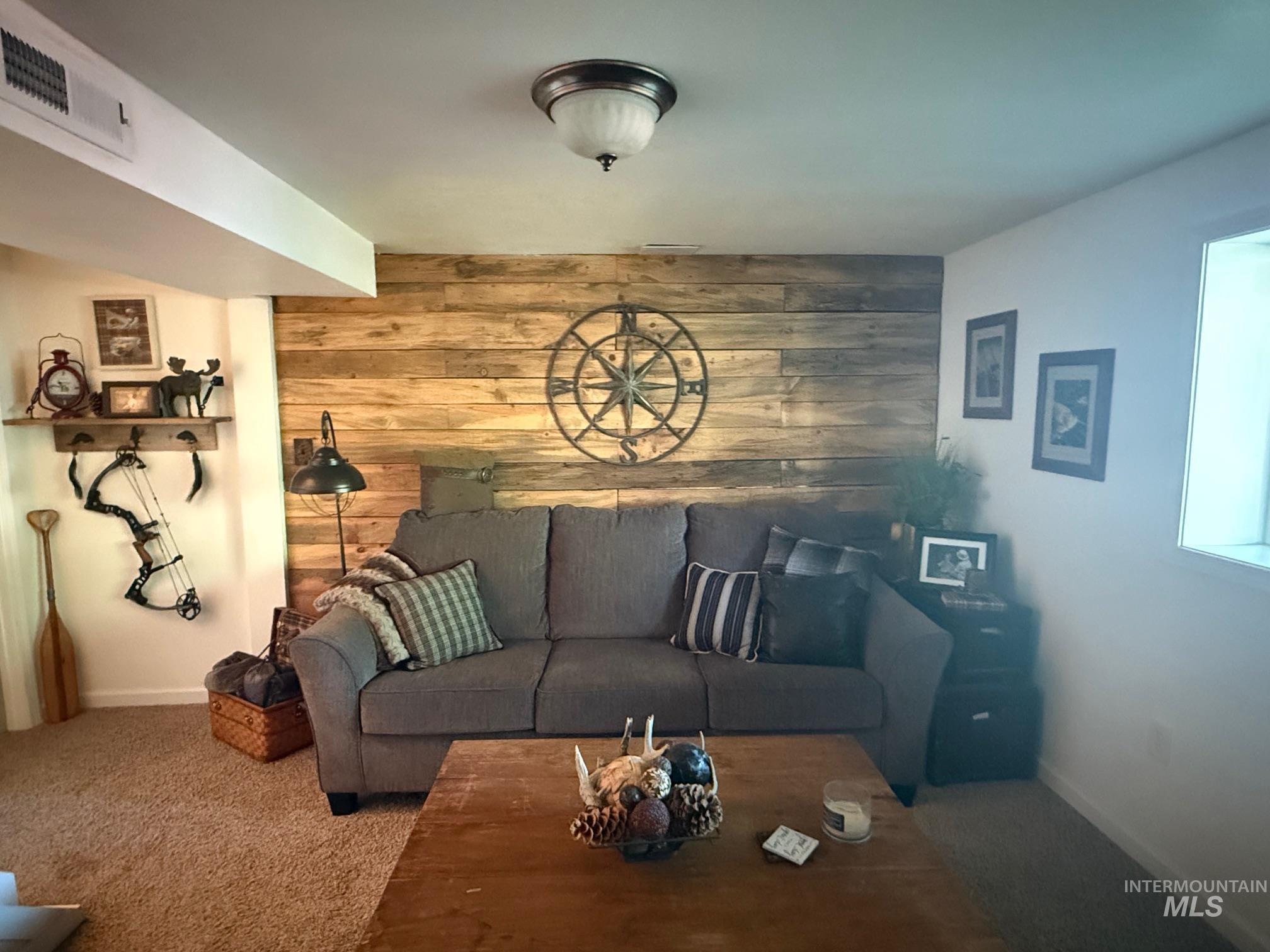 403 138th Street Orofino, ID 83544 - Photo 22 of 32 Carpeted living area featuring wooden walls and baseboards