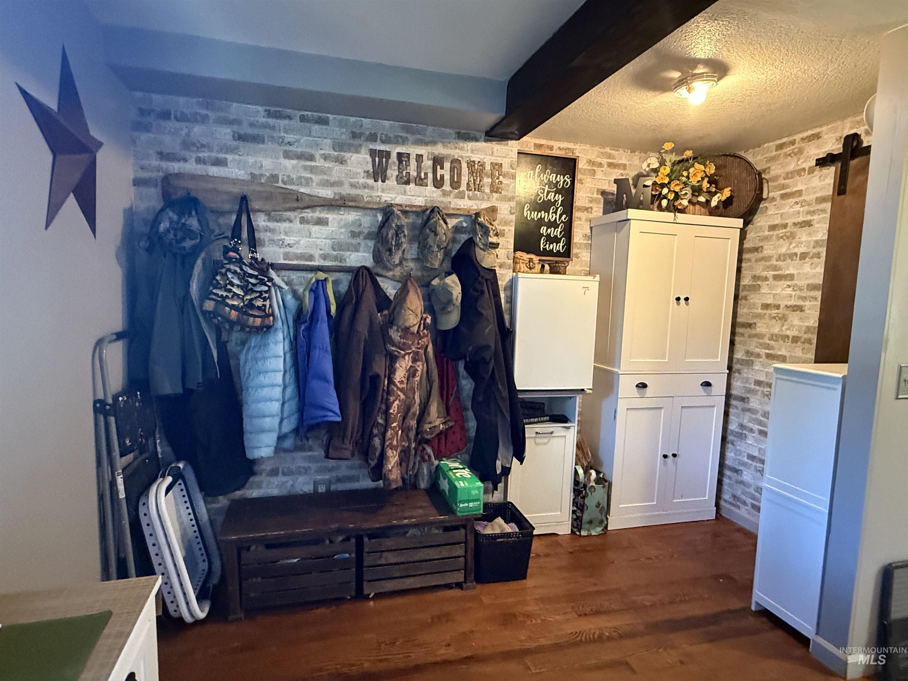 403 138th Street Orofino, ID 83544 - Photo 4 of 32 Mudroom with brick wall, wood finished floors, and beam ceiling