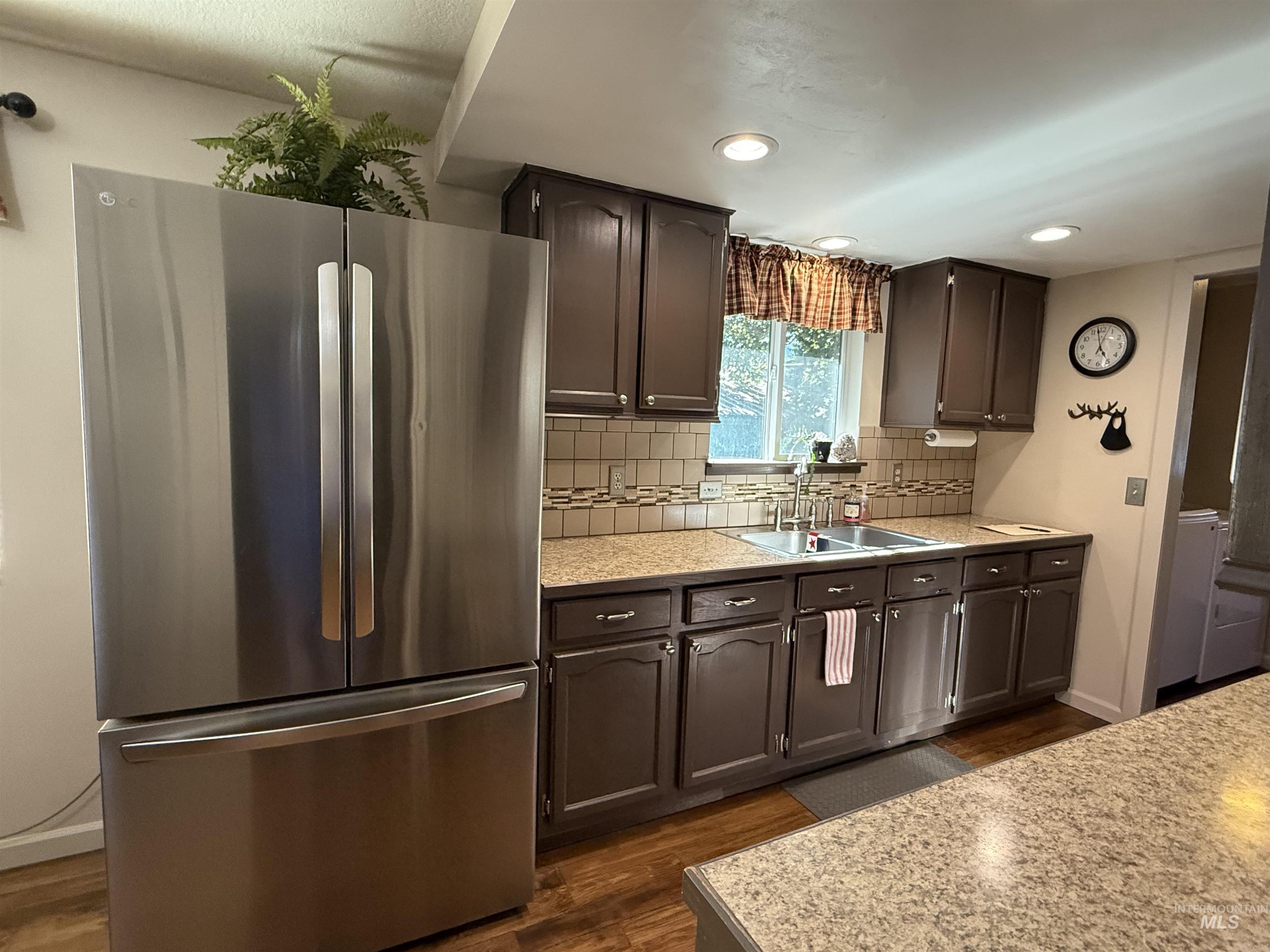 403 138th Street Orofino, ID 83544 - Photo 5 of 32 Kitchen featuring freestanding refrigerator, light countertops, dark wood-type flooring, decorative backsplash, and recessed lighting