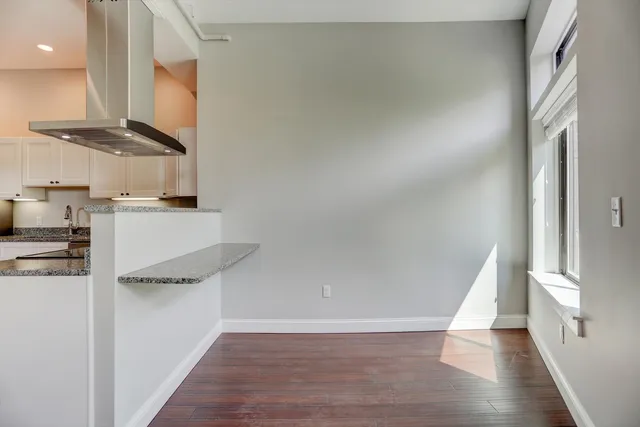 a kitchen with granite countertop a refrigerator and a stove top oven