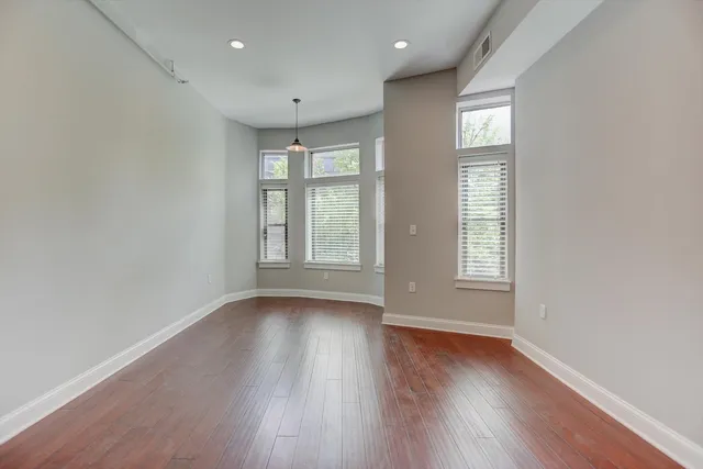 a view of a hallway with wooden floor and a living room