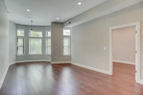 a view of a room with wooden floors and window