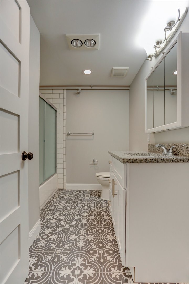218 West Main Street Urbana, IL 61801 - Photo 35 of 96 a bathroom with a granite countertop sink a toilet and shower