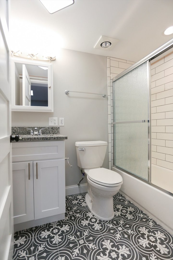 218 West Main Street Urbana, IL 61801 - Photo 71 of 96 a bathroom with a granite countertop toilet a sink and a mirror