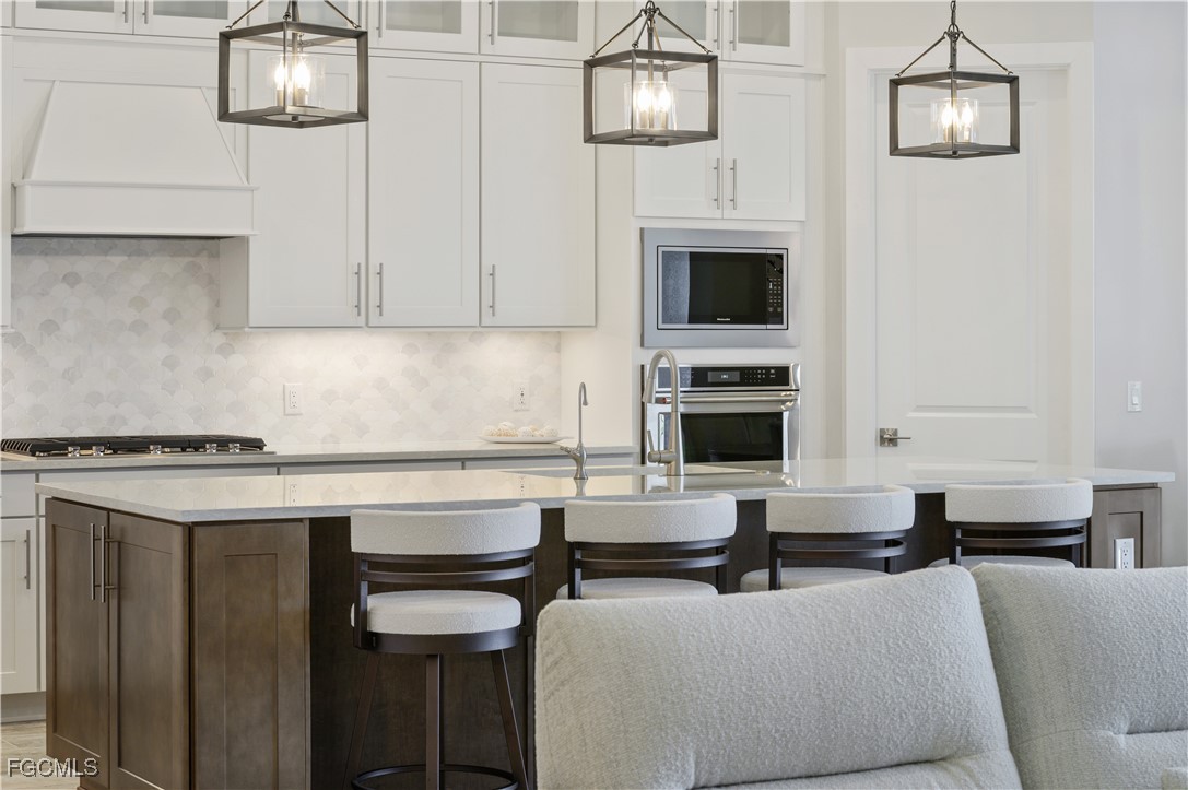 18377 Ridgeline Drive Estero, FL 33928 - Photo 15 of 50 a kitchen with stainless steel appliances a stove top oven a sink a counter space and cabinets