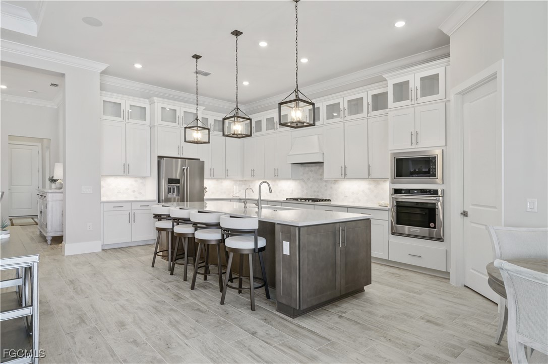 18377 Ridgeline Drive Estero, FL 33928 - Photo 16 of 50 a large kitchen with stainless steel appliances kitchen island a large island in the center
