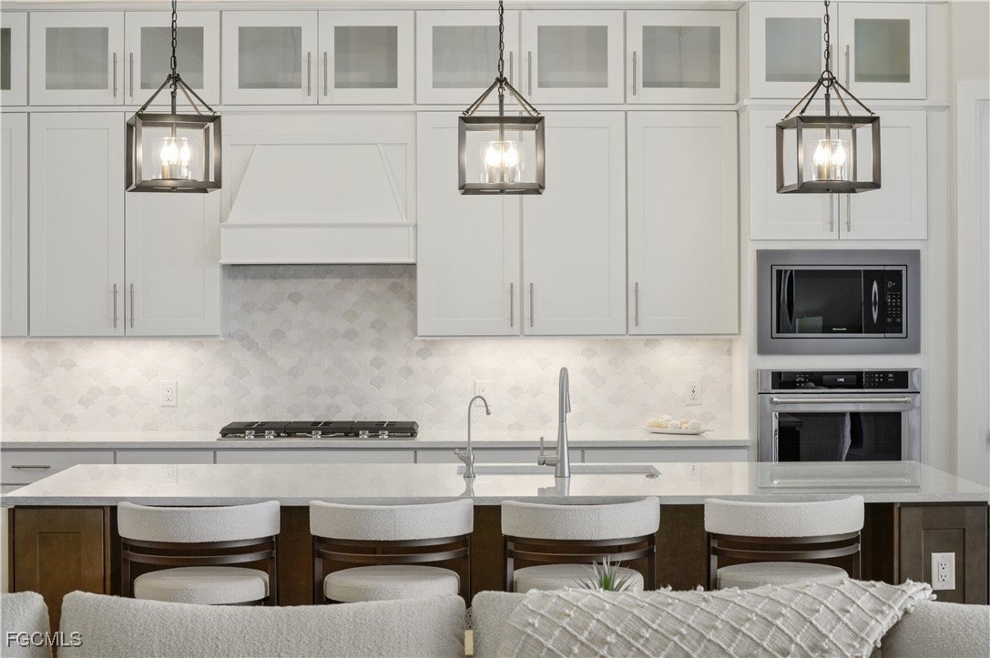 18377 Ridgeline Drive Estero, FL 33928 - Photo 17 of 50 a kitchen with a stove and a white cabinets