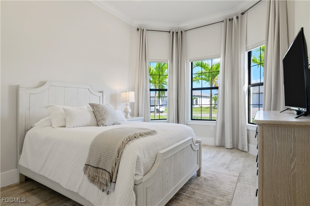 18377 Ridgeline Drive Estero, FL 33928 - Photo 31 of 50 a spacious bedroom with a bed and a flat tv screen on dresser