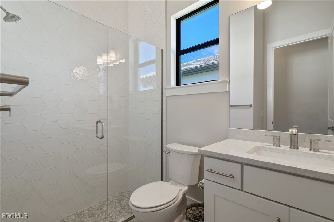 18377 Ridgeline Drive Estero, FL 33928 - Photo 33 of 50 a bathroom with a toilet a sink a shower and mirror