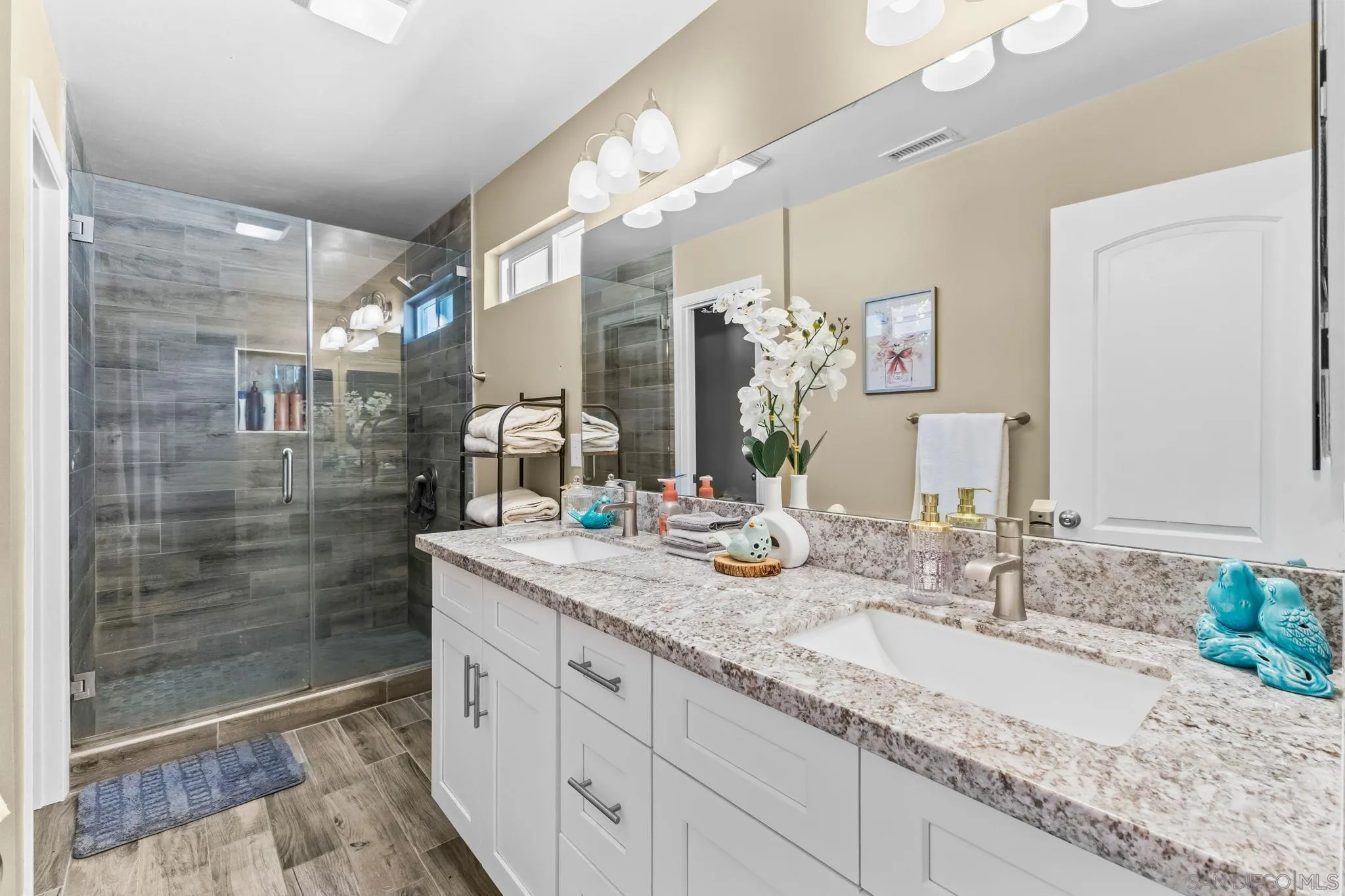 903 Concepcion Avenue Spring Valley, CA 91977 - Photo 29 of 69 a bathroom with a granite countertop sink a mirror and a shower