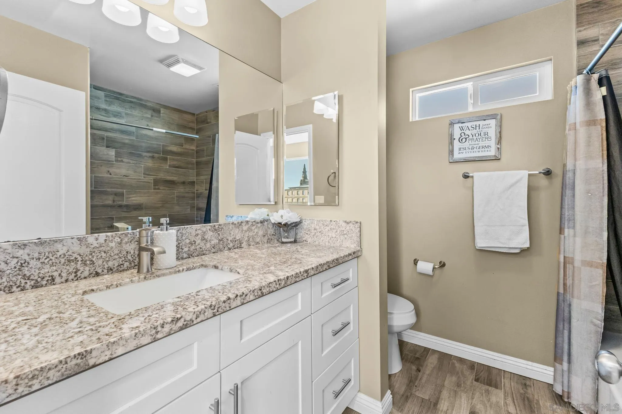 903 Concepcion Avenue Spring Valley, CA 91977 - Photo 30 of 69 a bathroom with a granite countertop sink and a mirror