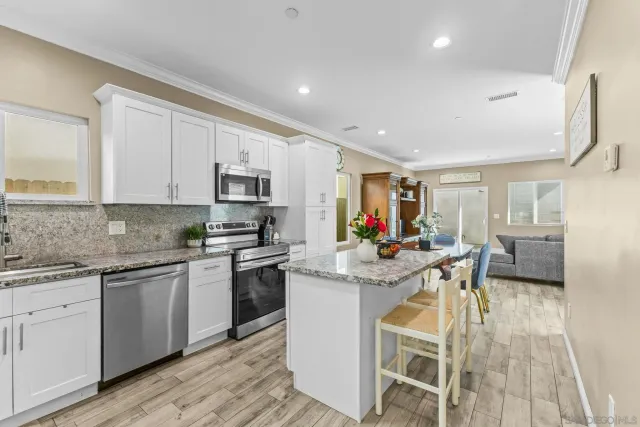 a kitchen that has a sink cabinets counter space and appliances