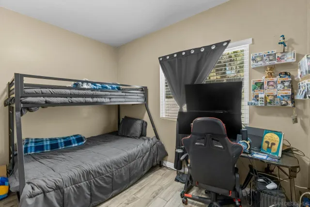 a bedroom with a bed and wooden floor