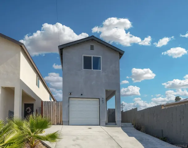 a front view of a house with plants