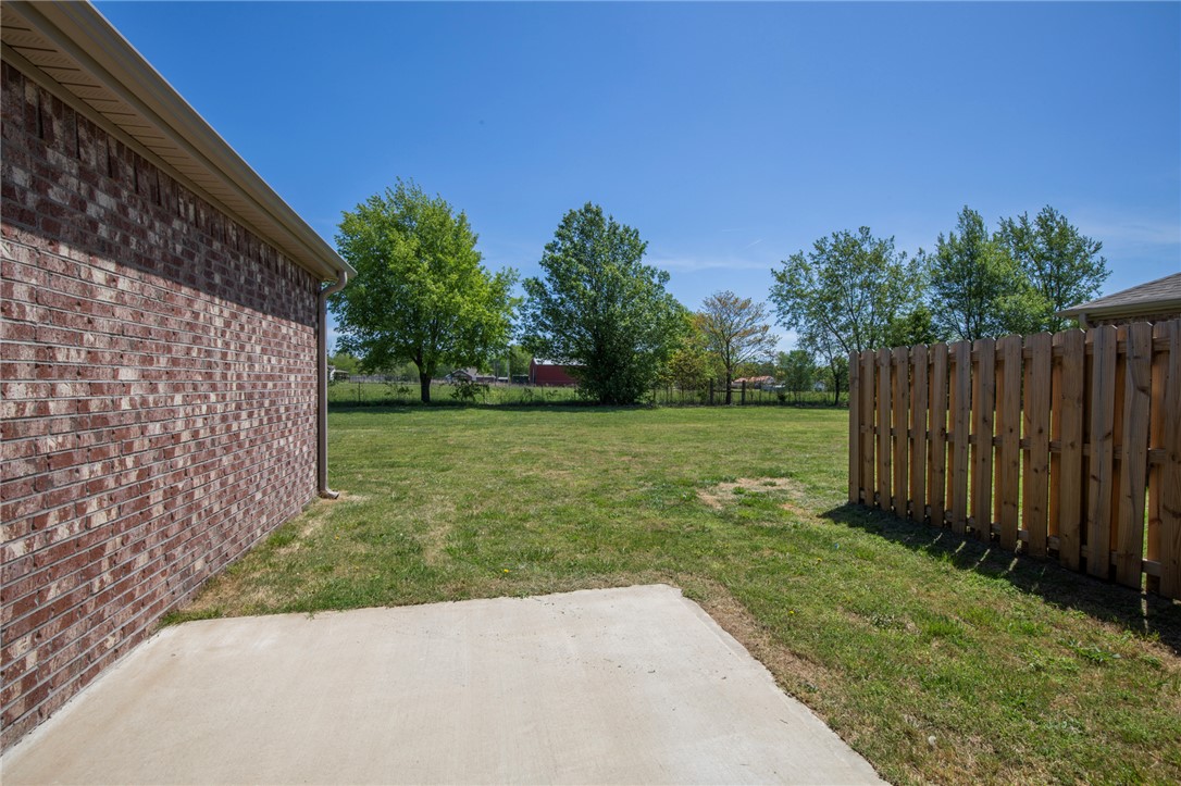 214 Alder Street Pea Ridge, AR 72751 - Photo 4 of 20 Expansive green lawn with a privacy fence and a concrete patio