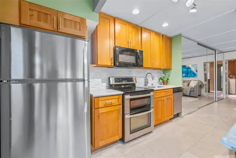 a kitchen with stainless steel appliances granite countertop a refrigerator a sink dishwasher stove and oven