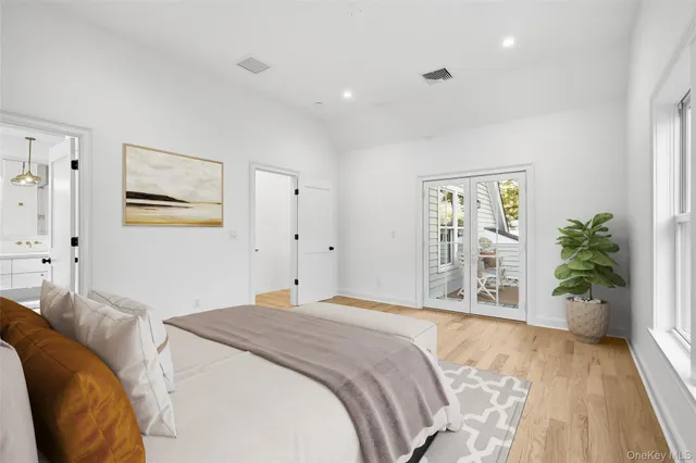 a bedroom with a large bed and a potted plant