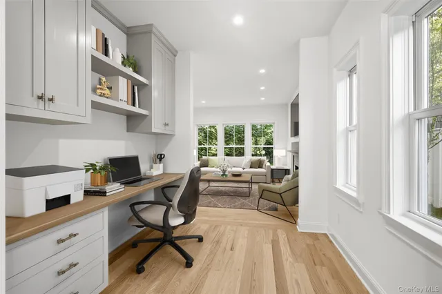 a view of a workspace with furniture and a window