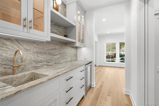 a kitchen with granite countertop a sink and a wooden floor