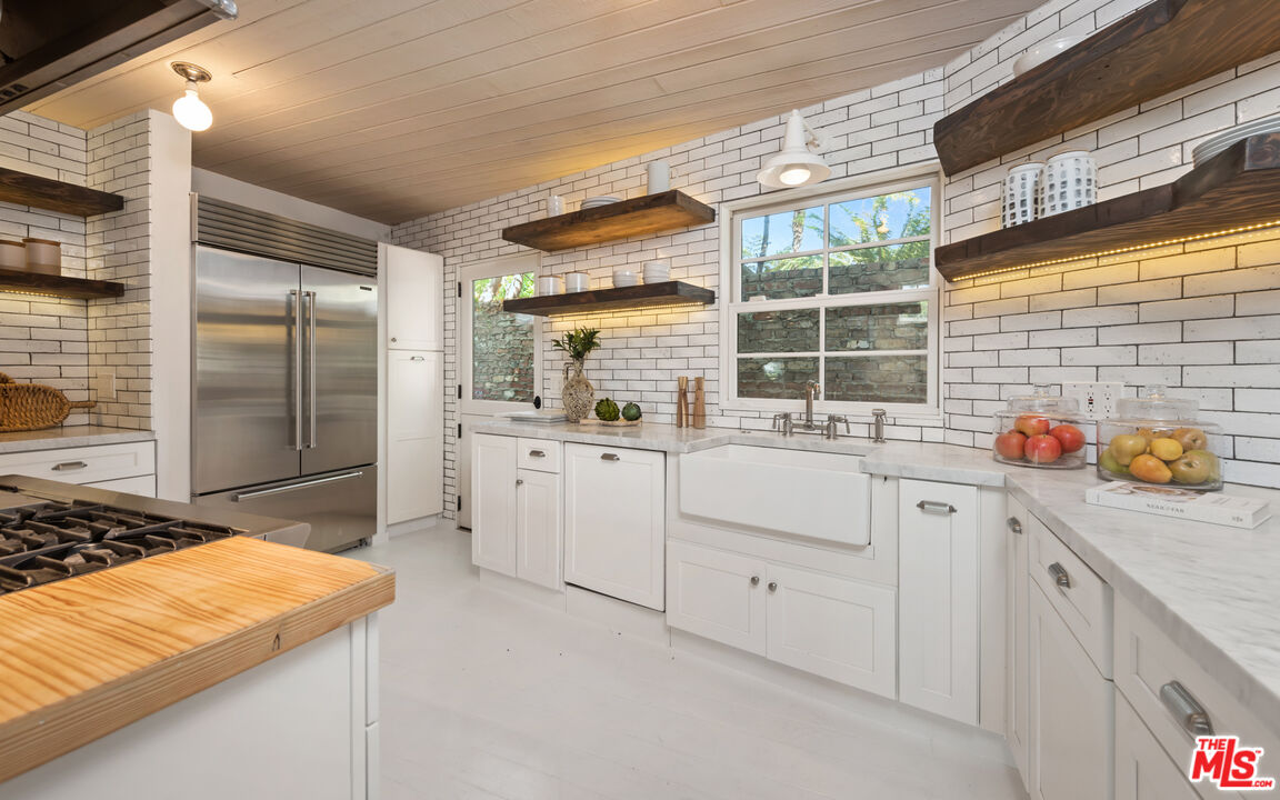 558 East Channel Road Santa Monica, CA 90402 - Photo 8 of 34 a kitchen with white cabinets and appliances