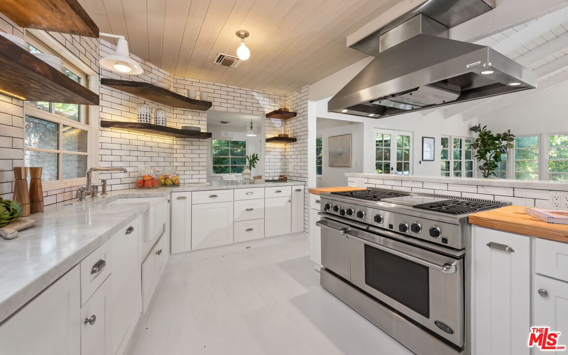 558 East Channel Road Santa Monica, CA 90402 - Photo 9 of 34 a kitchen with stainless steel appliances a stove and white cabinets
