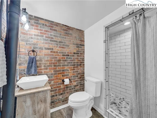 a living room with furniture a flat screen tv and a floor to ceiling window